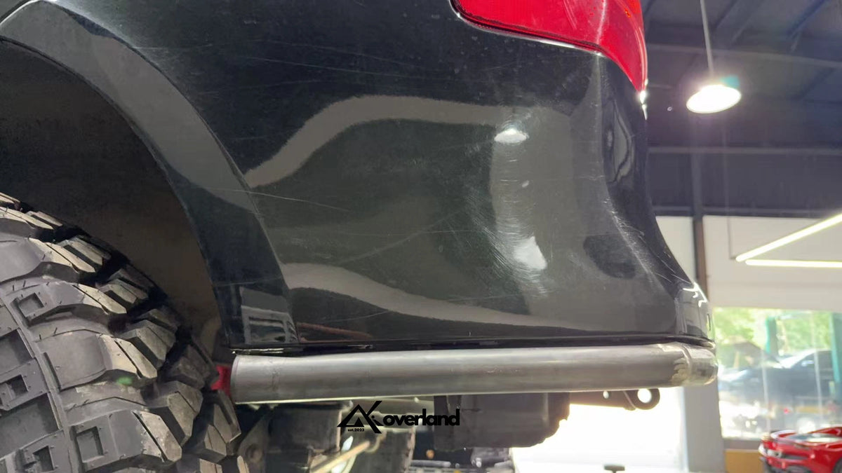 Side-angle view of tubular rear bumper highlighting tube curve, trimming clearance zone, and steel plate construction.