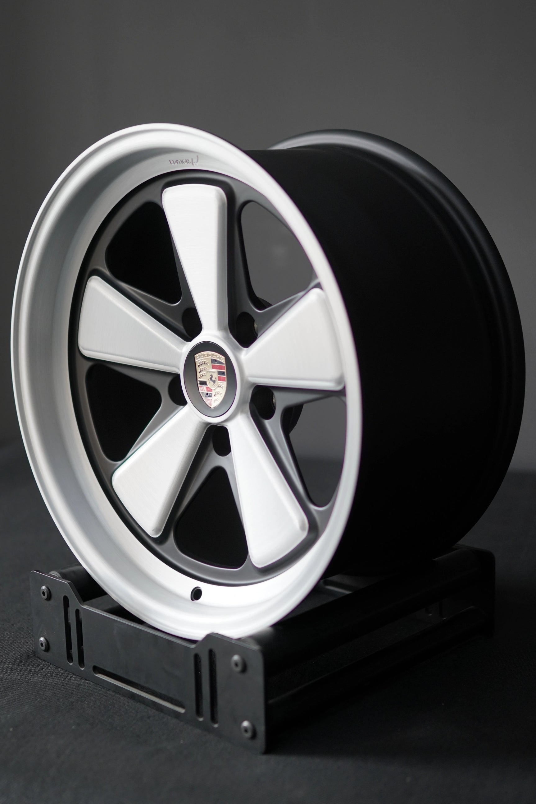 Porsche 5x130 Edition W forged wheel with brushed face and satin windows photographed on stand.