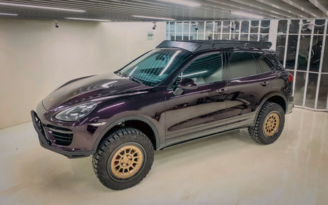 Purple Lifted Porsche Cayenne turbo S 958 with off-road tires in showroom