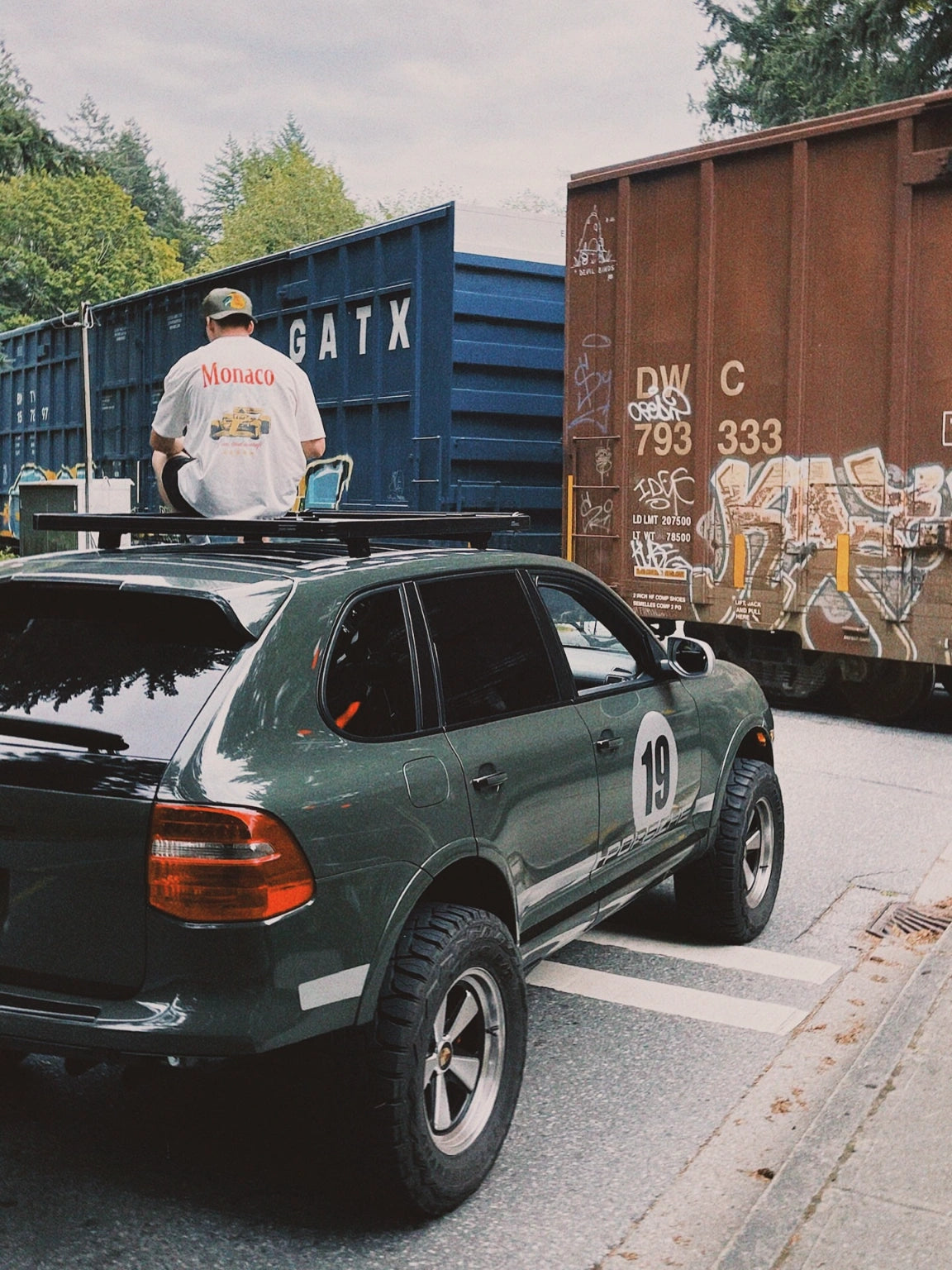 Cayenne 957 off-road build parked near shipping containers showing Akioverland modifications.”