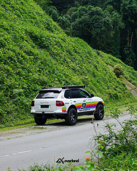 Porsche Cayenne offroad with apple rainbow livery in mountain in spring