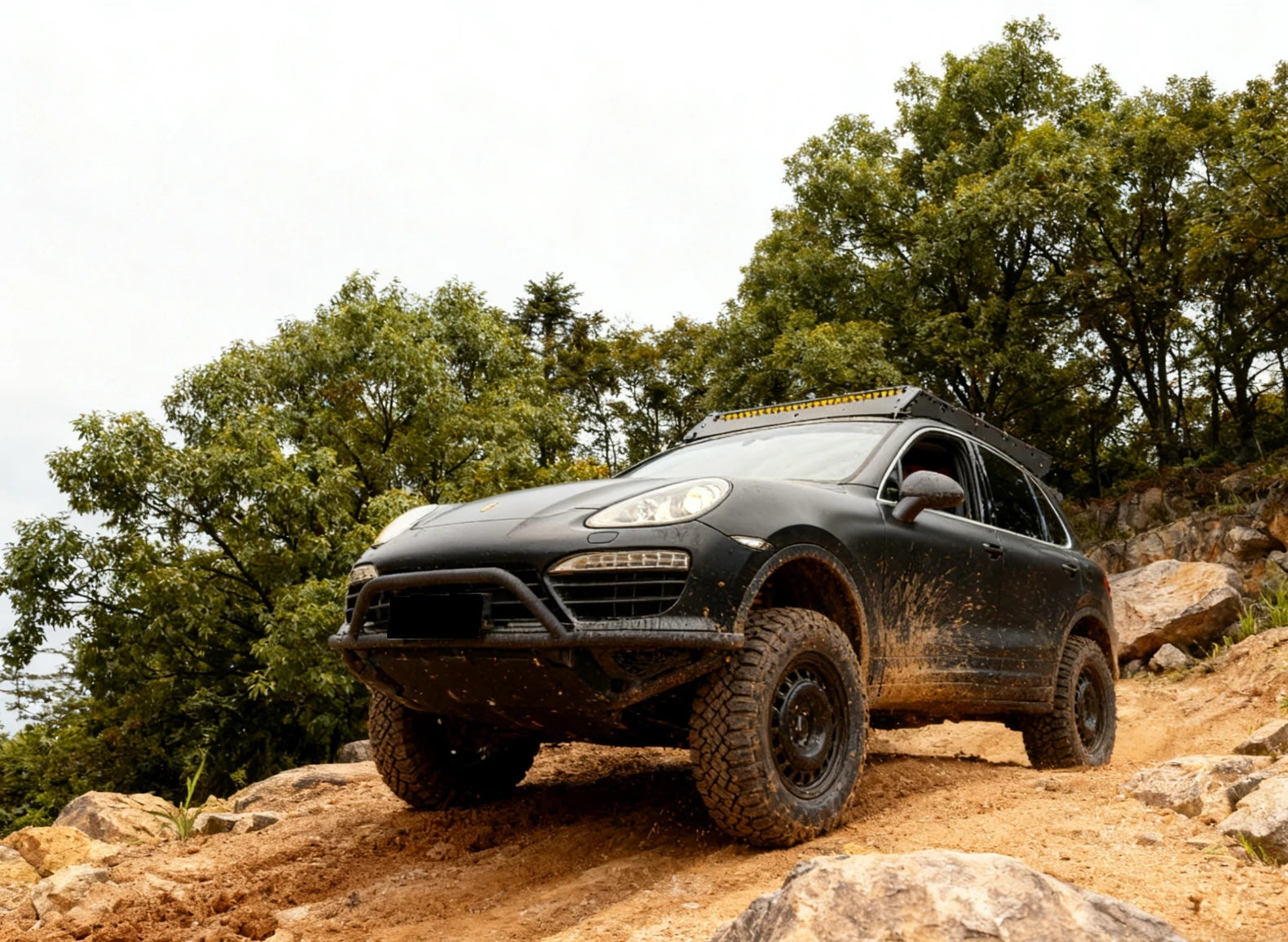 Cayenne 958 navigating uneven off-road trail with Akioverland UCA reinforcing steering precision and durability.