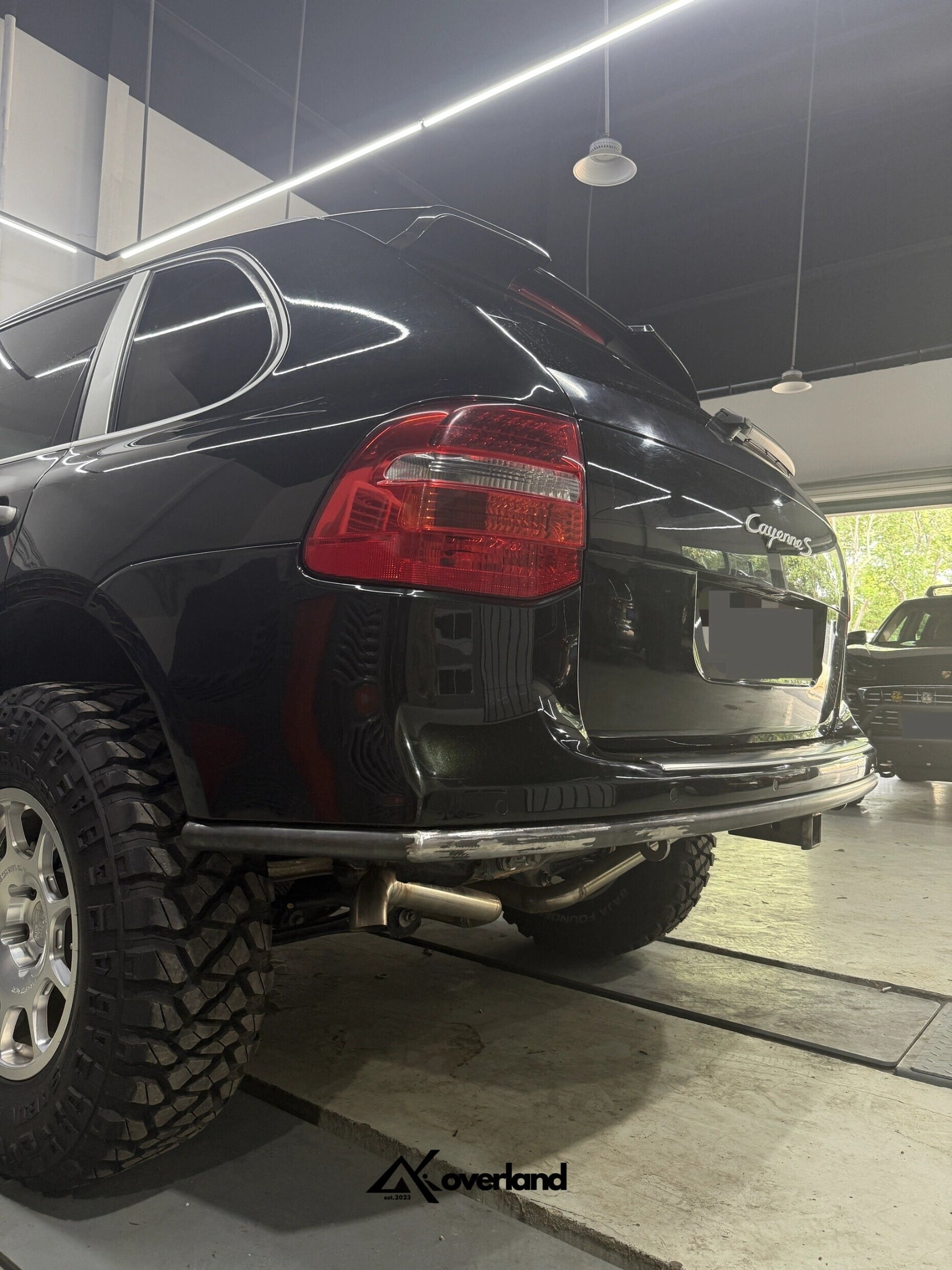 Porsche Cayenne 957 rear end with Akioverland steel tubular bumper featuring square recovery point for safe towing.