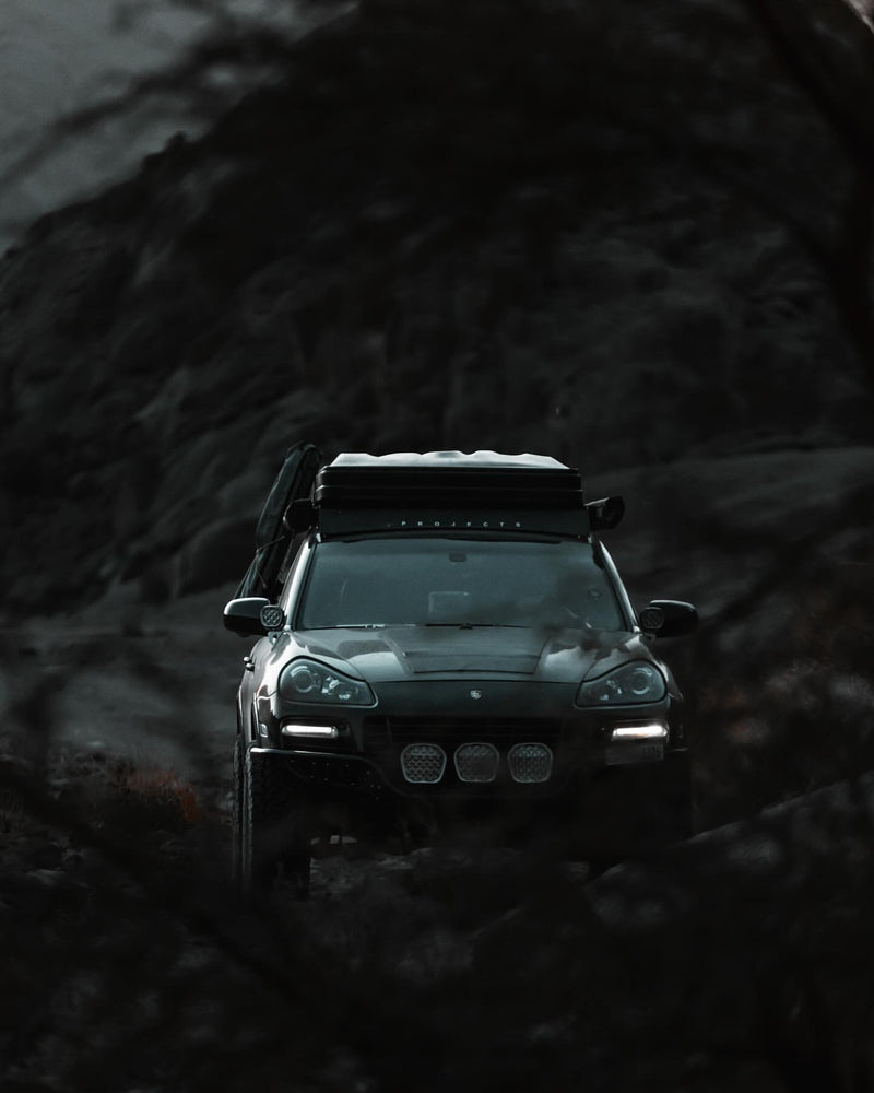 Lifted porsche Cayenne 957 GTS design edition with akioverland coilovers in kuwait desert during sunset. Sherpa rack cayenne, rhino wheels 5x130,solid project custom bumper and stedi light