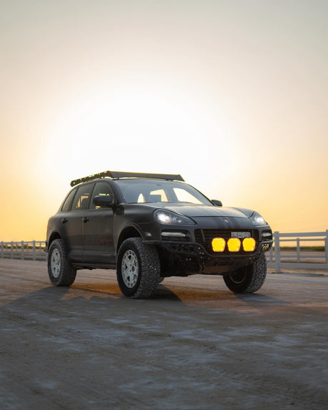 Lifted porsche Cayenne 957 GTS design edition with akioverland coilovers in kuwait desert during sunset. Sherpa rack cayenne, rhino wheels 5x130,solid project custom bumper and stedi light