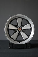 Edition W forged Fuchs-style wheel in 5x130 fitment for Porsche, studio-mounted on display stand.