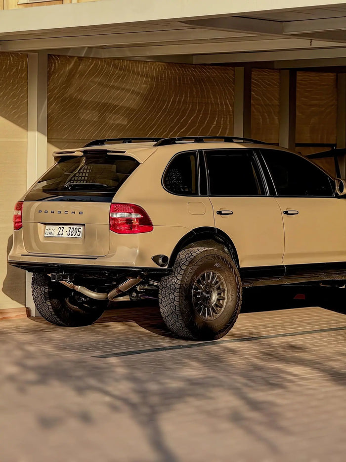 Sand colour Porsche Cayenne S 957 offroad build parked under a carport with akioverland coilovers