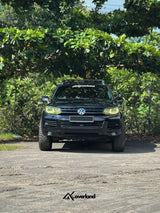 Lifted VW Touareg 7P with widebody fenders running Akioverland 2.5-inch spring lift kit and V3 subframe, engine, and transmission drop system for corrected geometry.