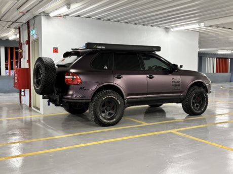 Matte purple Cayenne 957 Turbo offroad build by akioverland. Equipped with super slim roof rack, air suspnesion lift kit and dual swing out tubular bumper. 