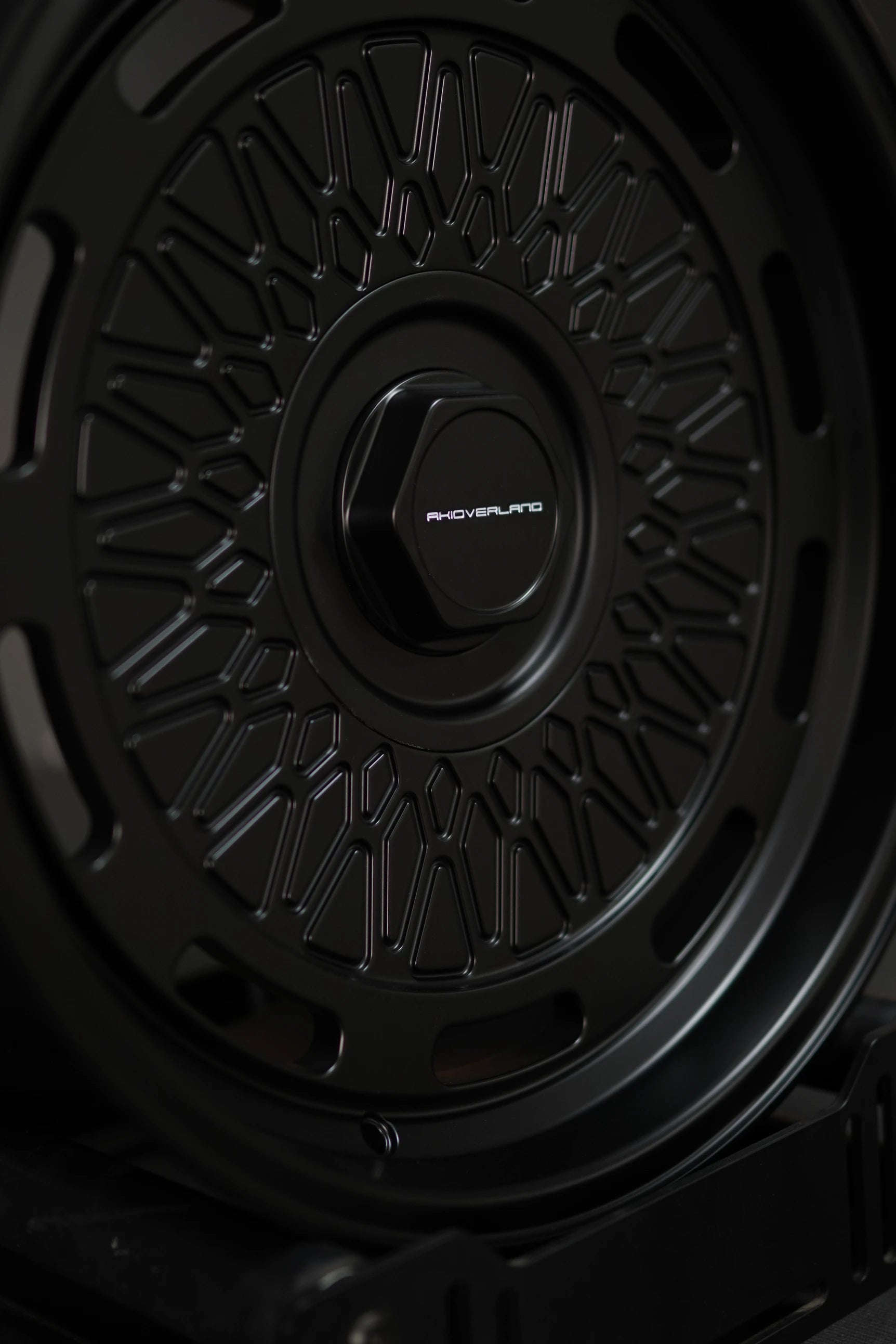 Studio shot of AkiOverland 5x130 mesh wheels in black – premium forged wheels for Porsche offroad builds.
