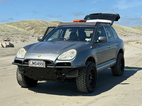 Porsche Cayenne 955 Turbo with tubular bumper driving on beach overland setup