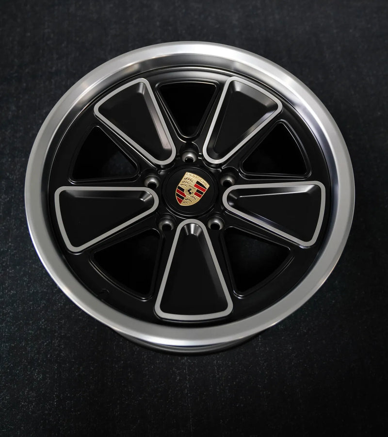 AkiOverland Fuchs Reimagined forged wheel face detail — matte black with CNC-machined spoke highlights and polished outer lip, 5x130 Porsche fitment