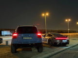 Rear view of a lifted Porsche Cayenne 957 Turbo on Akioverland's 3.5" air lift, alongside a Porsche 992