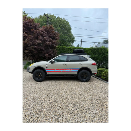 AkiOverland Porsche Cayenne 958 overland build on Classic Fuchs wheels in satin black with tubular bumper, roof rack and AkiOverland lift kit