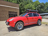 Classic red first-generation Porsche Cayenne 955 running AkiOverland Cookie Cutter Rugged forged wheels in machined and grey 2 Tone