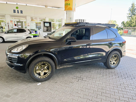 Porsche Cayenne 958 on AkiOverland 5x130 Forged Cookie Cutter Rugged wheels in special Bronze Neon finish with a green tint, front three-quarter view