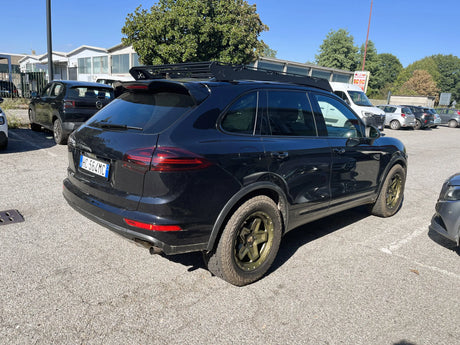 Rear three-quarter view of a Porsche Cayenne 958 fitted with AkiOverland Cookie Cutter Rugged forged wheels in special Bronze Neon
