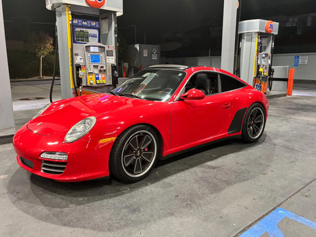 Red Porsche 997 fitted with AkiOverland custom Fuchs Reimagined forged wheels, front three-quarter view