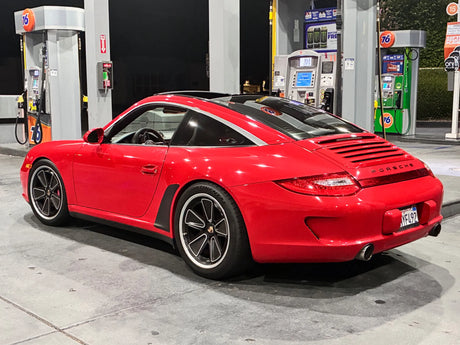 Rear three-quarter view of a red Porsche 997 with AkiOverland 5x130 Fuchs Reimagined custom wheels
