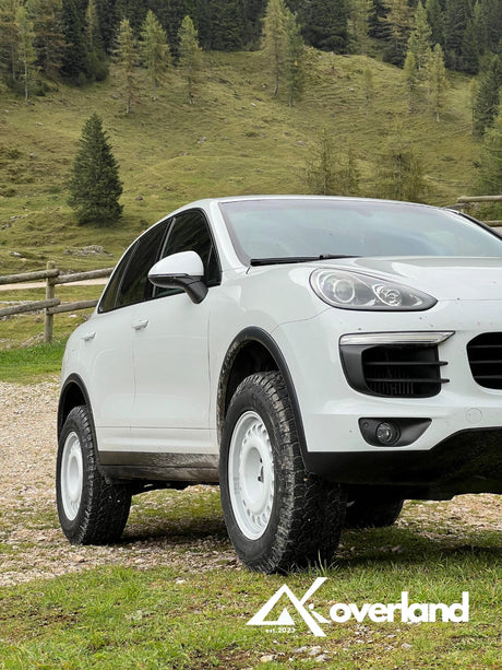 Lifted Porsche Cayenne 958 with Akioverland spring suspension system, increased ground clearance, and rugged off-road wheel setup for overlanding