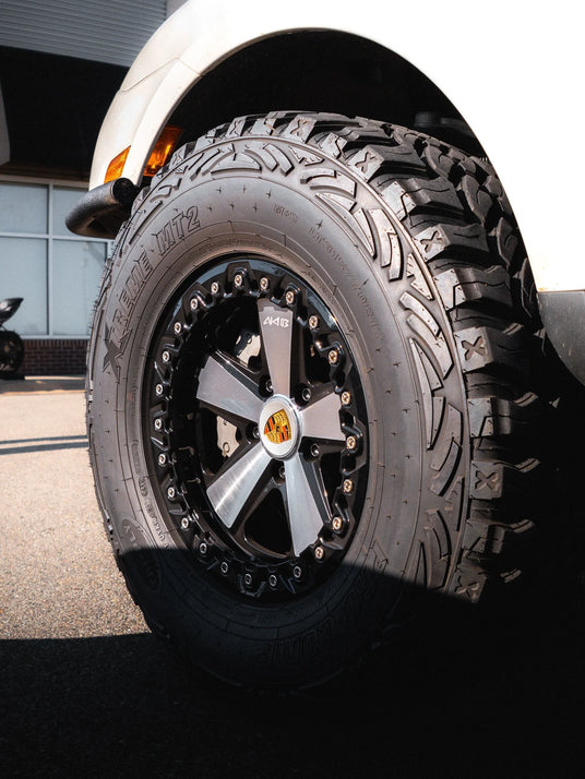 Porsche Cayenne 957 side view with Akioverland 5x130 Beadlock Fuchs wheel installed for off-road and overland use.