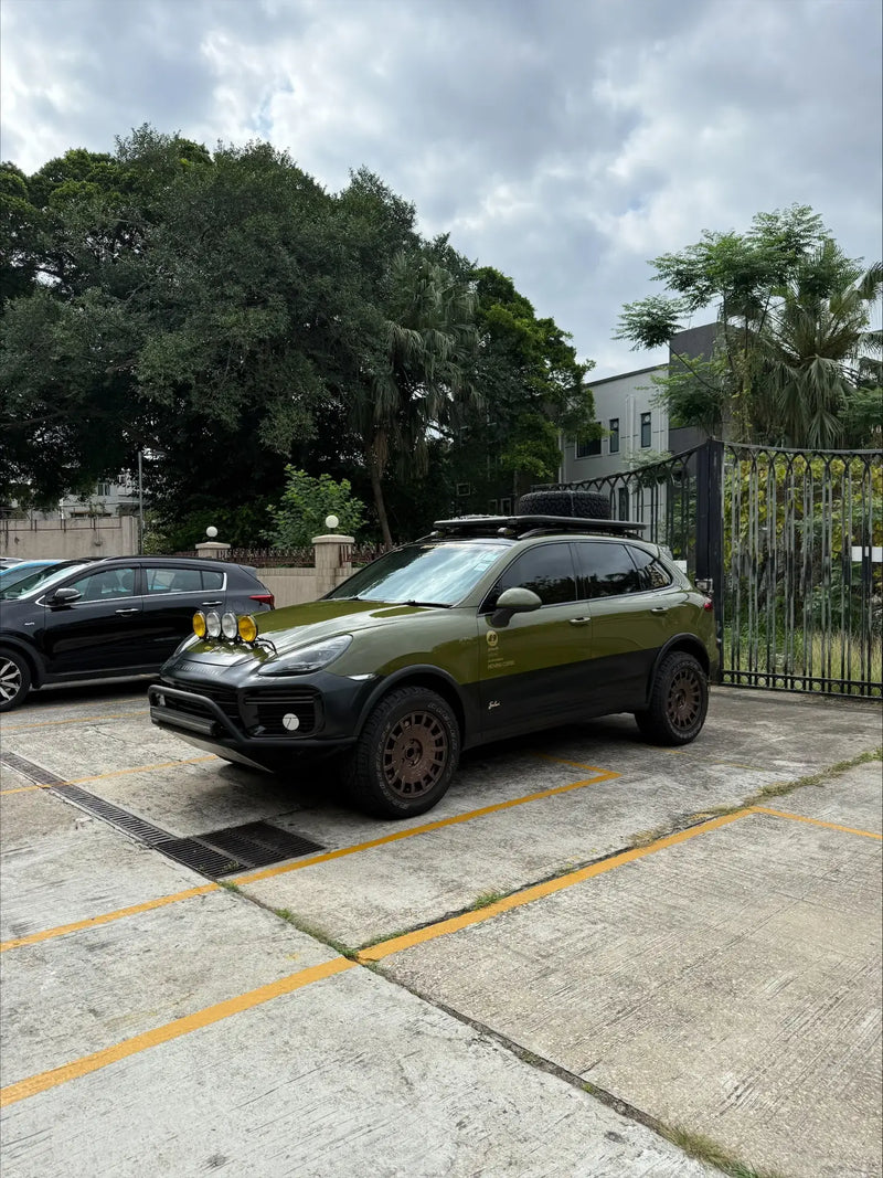 olive green Porsche Cayenne 958 with tubular offroad bumper and lifted suspension