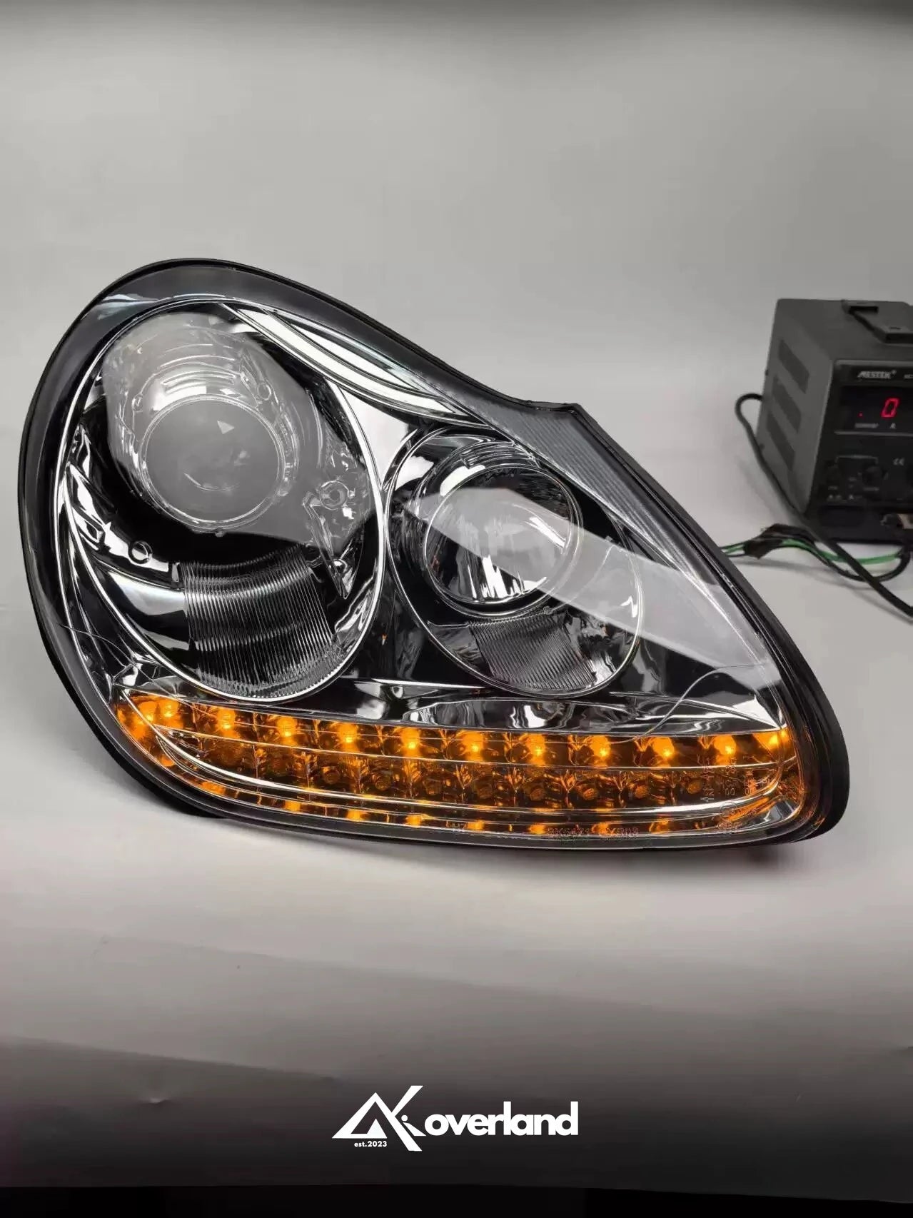 Porsche Cayenne 955 LED projector headlight showing amber turn signal and upgraded lighting design.