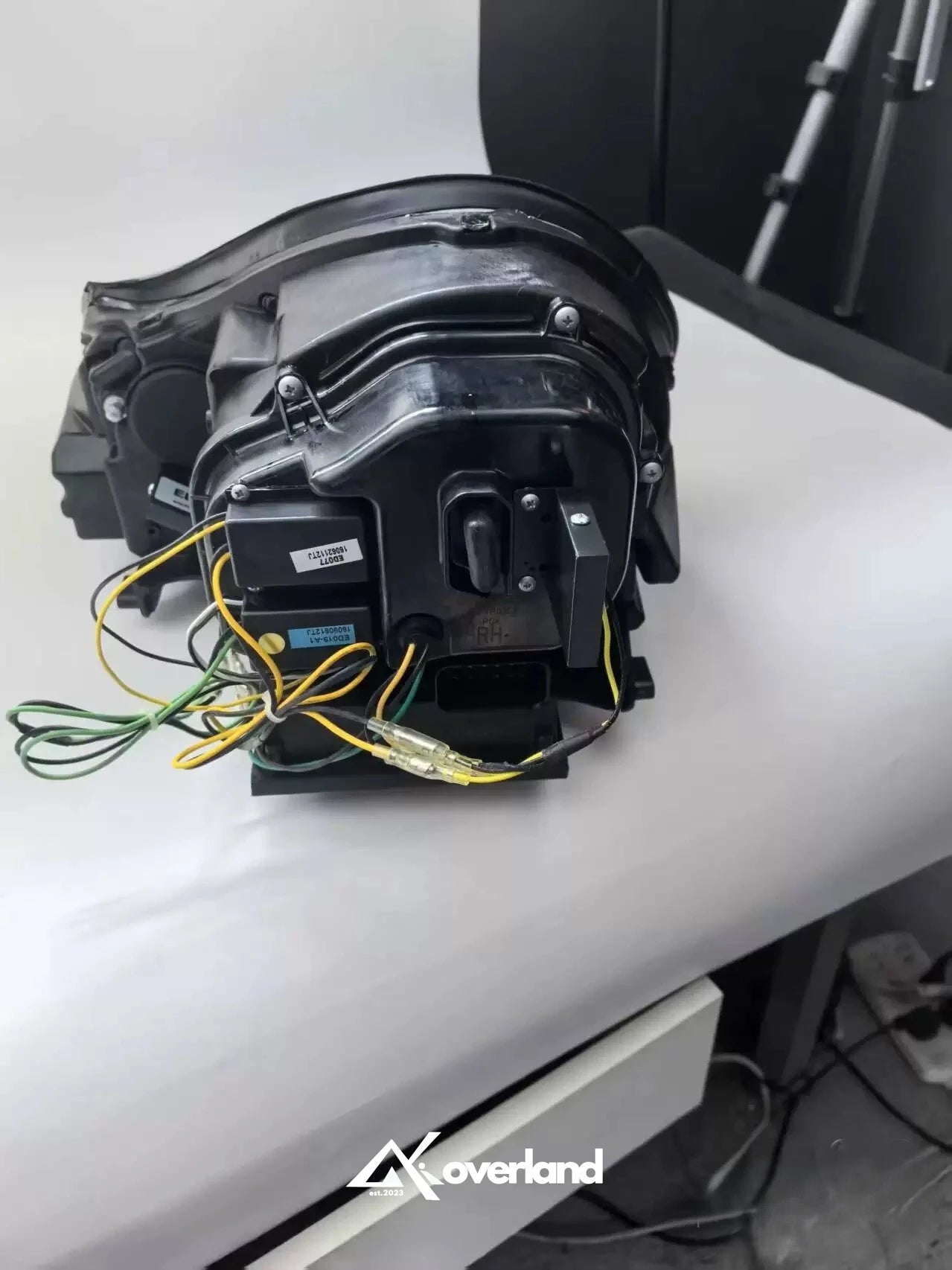 Rear wiring view of Porsche Cayenne 955 LED projector headlight showing connector and installation harness.