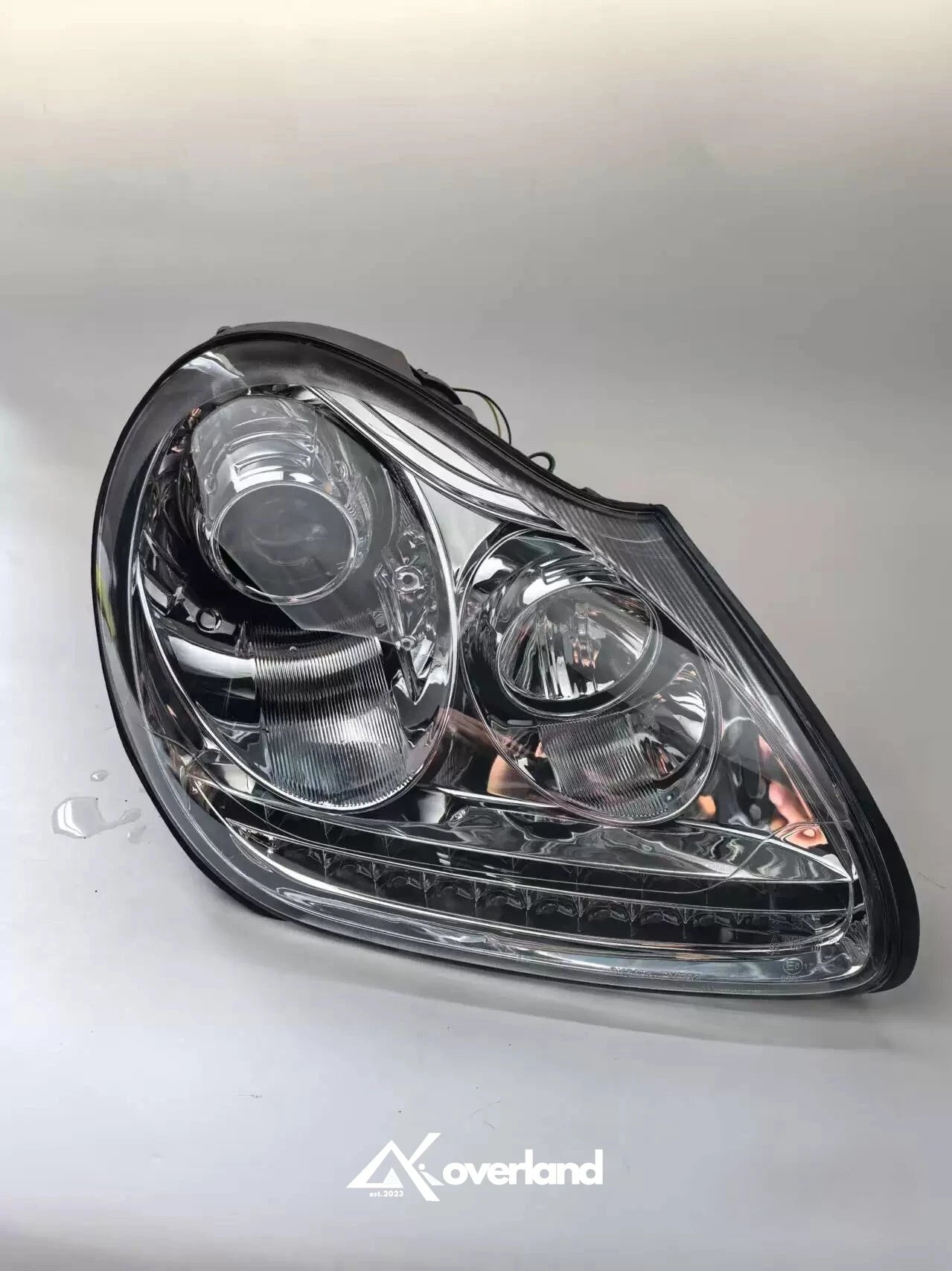 Porsche Cayenne 955 LED projector headlight with chrome housing and modern DRL upgrade.