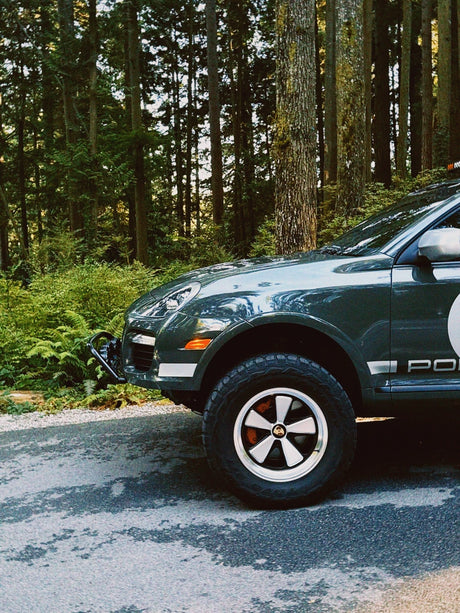 Porsche Cayenne 957 with rally number 19 decal on Edition W forged wheels by AkiOverland, parked on a forest trail