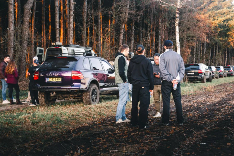Porsche Cayenne overland community gathering with expedition builds in European forest