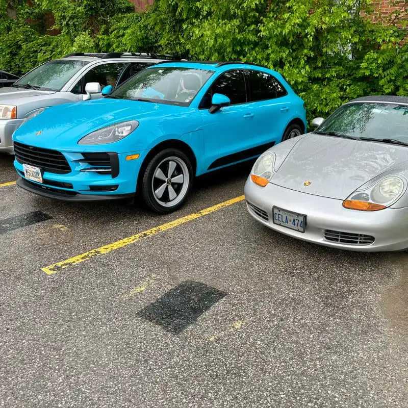 2021 Porsche Macan Miami Blue Sully front view parked next to silver Porsche 996 Carrera in rainy Cleveland Ohio parking lot — Sully build community moment, pre-Edition W Forged Fuchs wheels