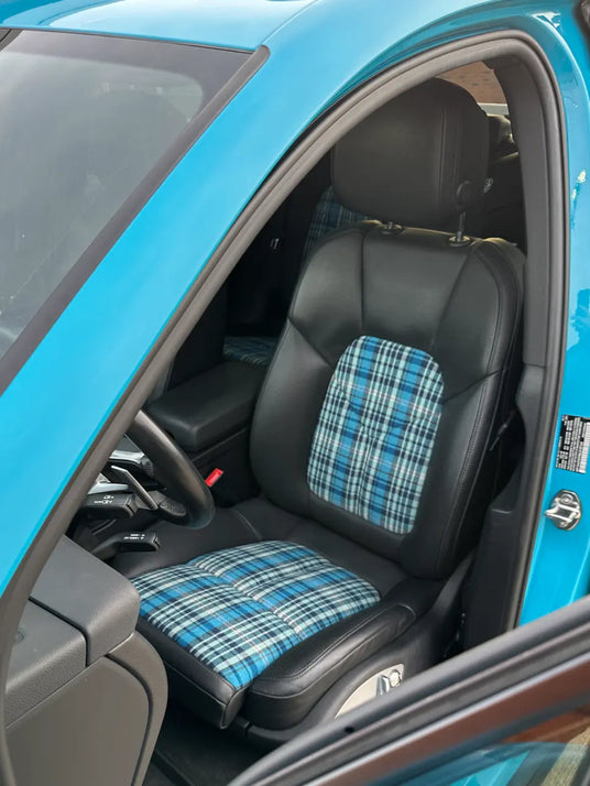 Close-up of Karo Madras plaid seat insert by Relicate fabric 5711 sewn by DuraMend in 2021 Porsche Macan Miami Blue Sully — driver seat and backrest showing blue pink white grey plaid pattern, Cleveland Ohio build detail