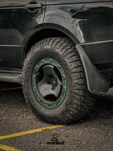 Close-up of 5x120 trispoke forged off-road wheel fitment on Range Rover L322 with lifted overland suspension.