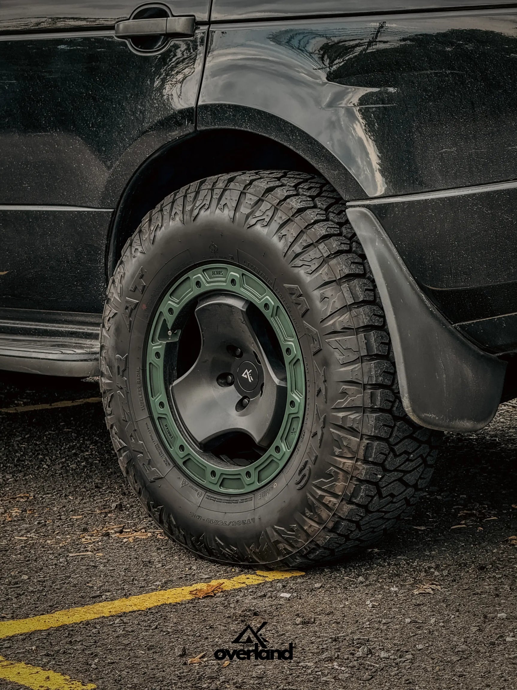 Close-up of 5x120 trispoke forged off-road wheel fitment on Range Rover L322 with lifted overland suspension.