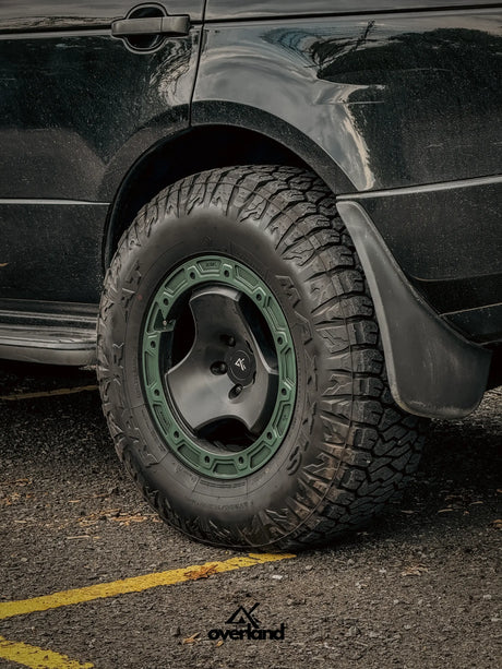 Close-up of 5x120 trispoke forged off-road wheel fitment on Range Rover L322 with lifted overland suspension.
