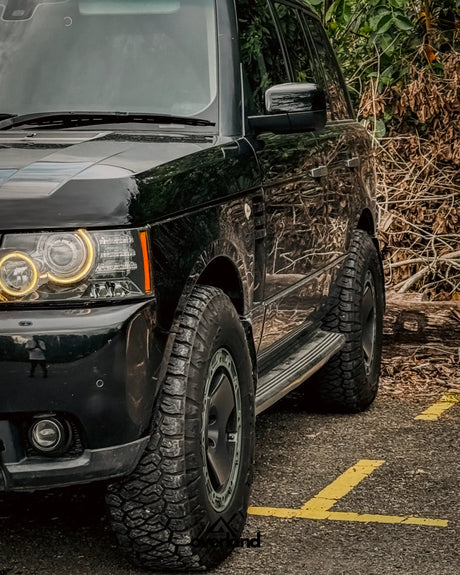 Front quarter angle of Range Rover L322 overland build with 5x120 trispoke forged wheels and lifted stance.