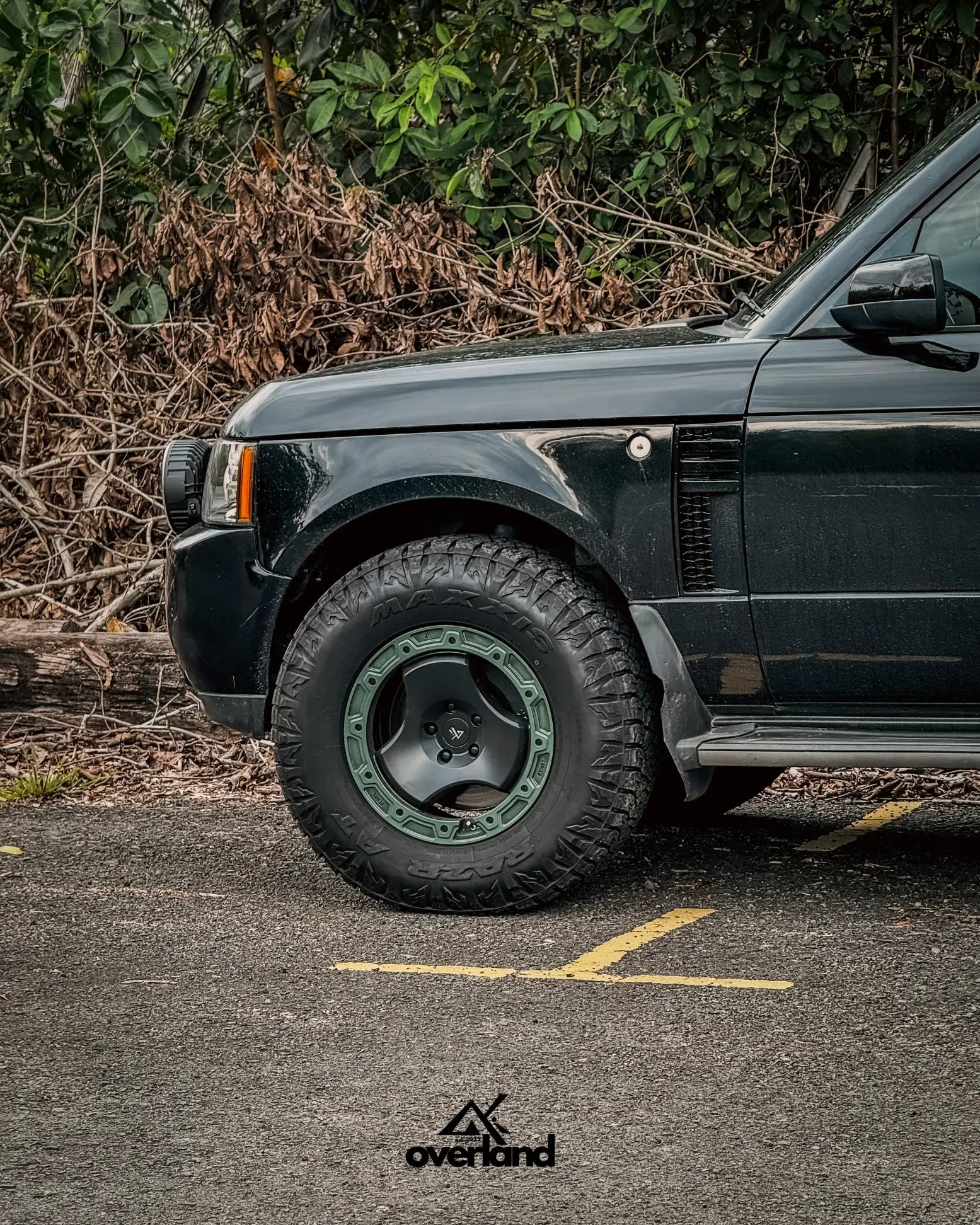 Matte green 5x120 trispoke forged off-road wheel installed on lifted Range Rover L322 with all-terrain tires.